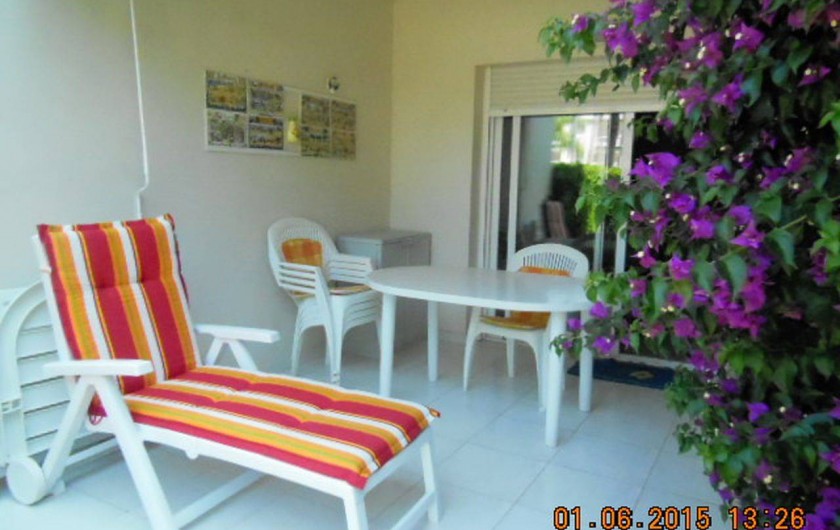 Location de vacances - Appartement à Dénia - la terrasse couverte agrémentée par le bougainvillier en fleurs