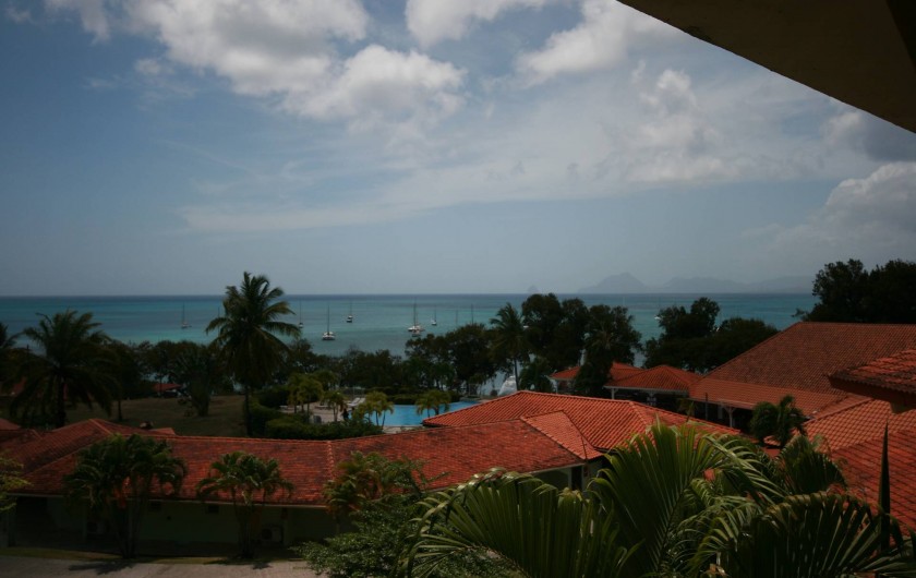 Location de vacances - Appartement à Sainte-Anne - Vue depuis le balcon sur le jardin, la piscine et la mer