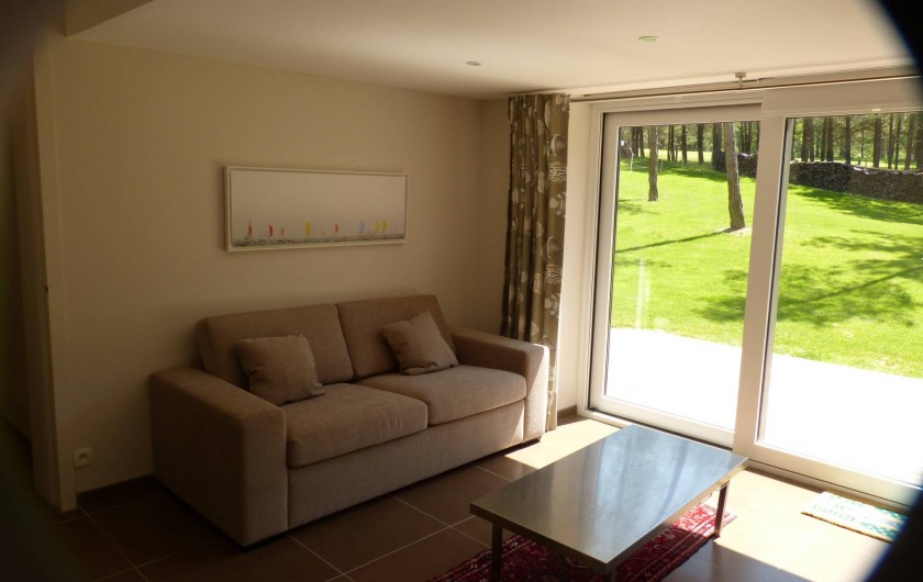 Location de vacances - Appartement à Hardelot-Plage - salon avec le divan lit et la vue sur le jardin et golf