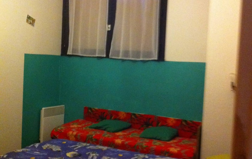 Location de vacances - Appartement à Super Besse - vue en entrant dans la chambre : lit double (bleu)+ lit d'enfant (rouge)
