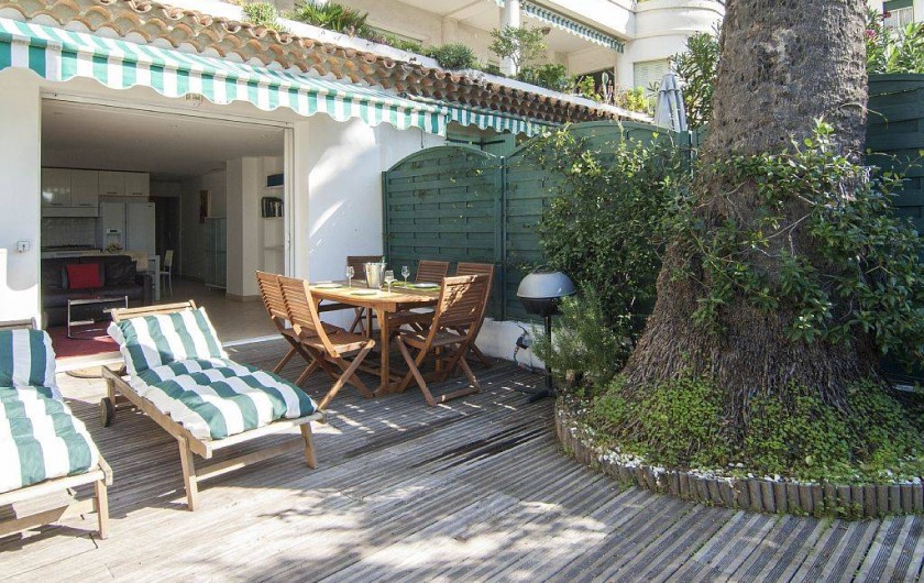 Location de vacances - Appartement à Cannes - Le jardin / terrasse : coin chaises longues, coin repas avec BBQ