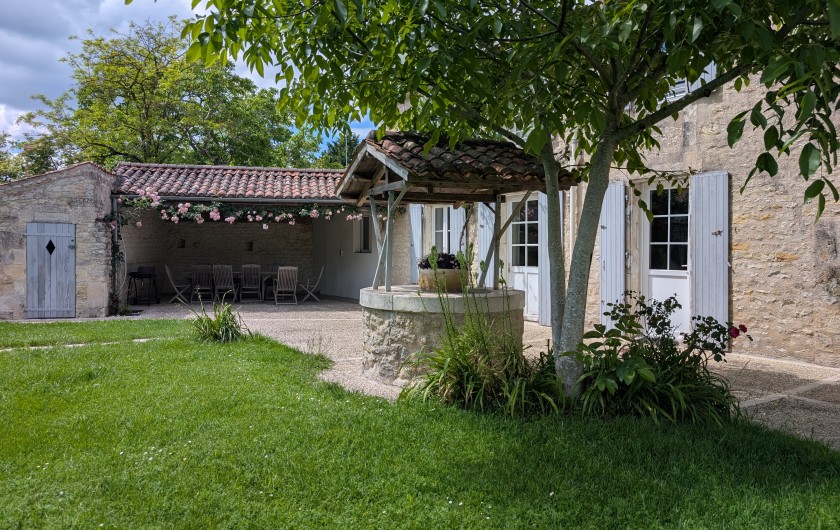 Location de vacances - Gîte à Surgères - Terrasse abritée et sa guirlande de roses odorantes au rpintemps