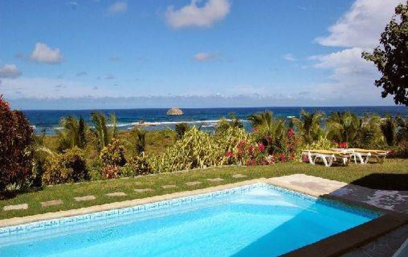 Location de vacances - Villa à Saint-François - Façade principale et terrasse vue sur mer. Meubles extérieurs et piscine.