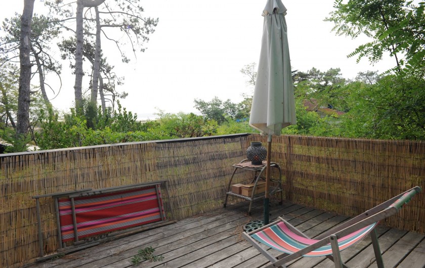 Location de vacances - Chalet à Le Cap Ferret - Coin droit de la terrasse , parasol chaises longues .