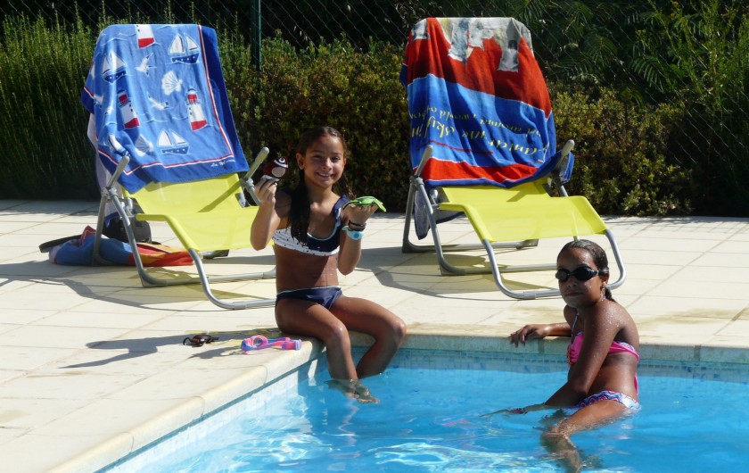 nos filles au bord de la piscine avec les fauteuils pliants