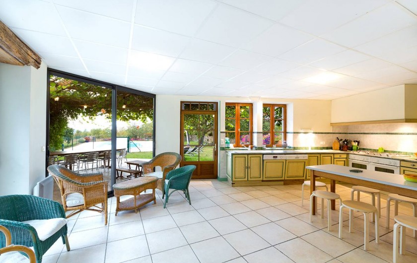 Location de vacances - Gîte à Loubressac - La cuisine qui donne sur l'extérieur : gloriette, piscine et jardin.