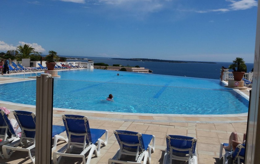 Location de vacances - Appartement à Cannes - Piscine vue depuis la terrasse du RESTAURANT. Au fond les  iles de LERIN.