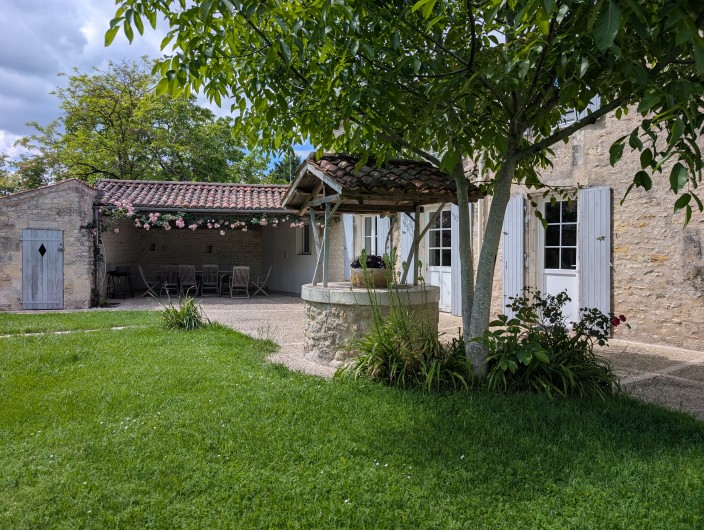 Location de vacances - Gîte à Surgères - Terrasse abritée et sa guirlande de roses odorantes au rpintemps