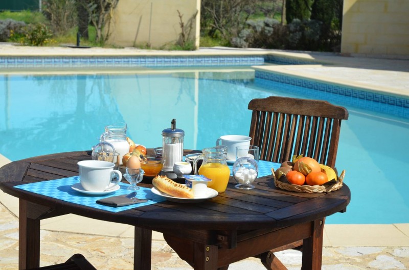 Location de vacances - Chambre d'hôtes à Vacquières - Petit déjeuner sur la terrasse au bord de la piscine